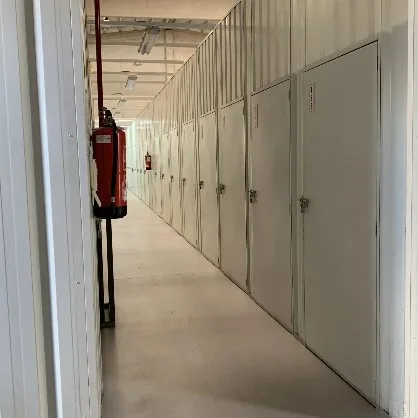 Pasillo con puertas de trasteros en la sede de Colmenar Viejo